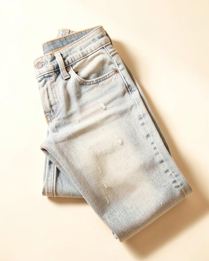 Light wash distressed straight leg jeans folded