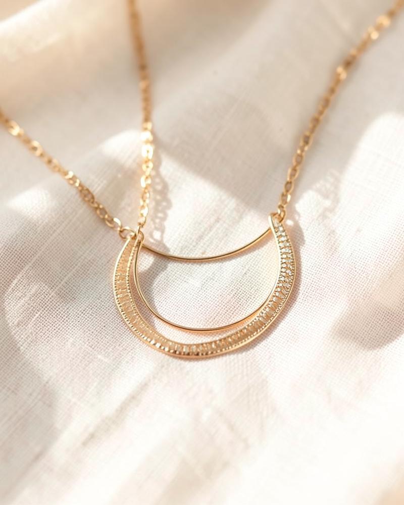 Delicate gold layered necklace on linen